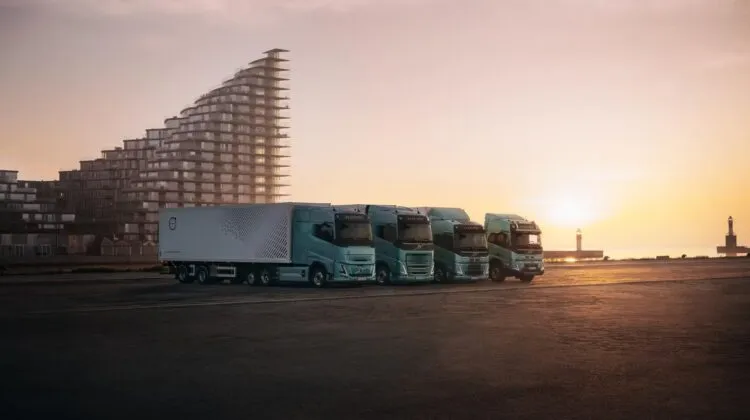 A lineup of four modern light-green Volvo electric heavy-duty commercial trucks. (Photo: Volvo Trucks)